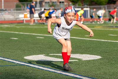 young girl running across football field