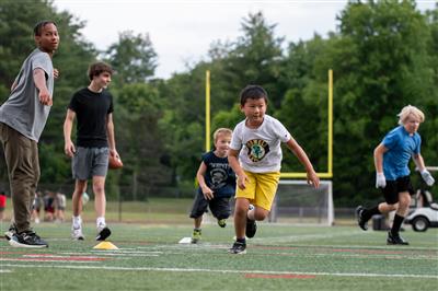 young boy running across field 