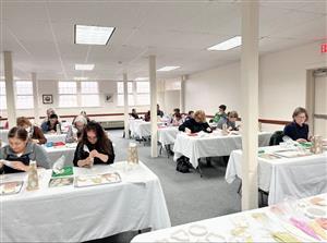 People sitting at tables decorating cookies in the Apple Barn