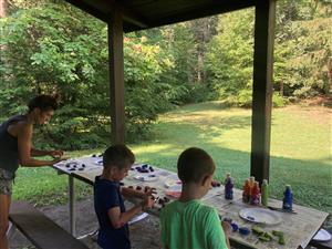 Two campers paint rocks at Town Forest Park