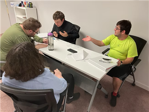 4 yound adults working on a film at a table together