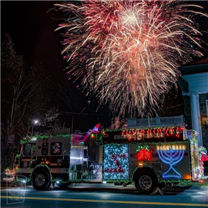 lighted Firetruck in front of fireworks