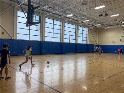 Kids playing kickball in a gym